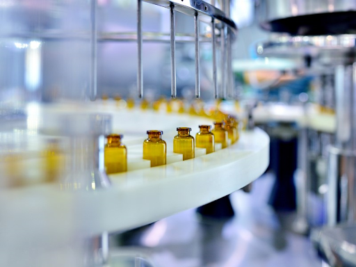 Brown glass bottles being filled on industrial machinery 